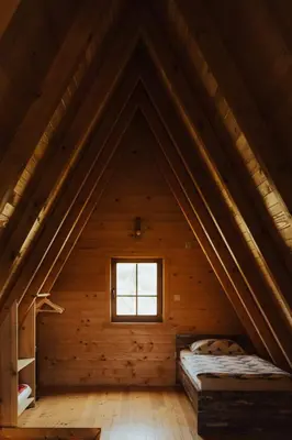 an attic room with a bed and a window at Ranč Crna stina in Livno