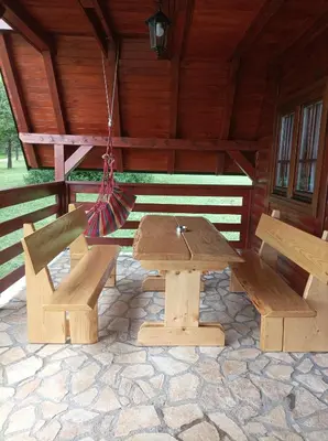 a wooden picnic table and bench in a cabin at Ranč Crna stina in Livno