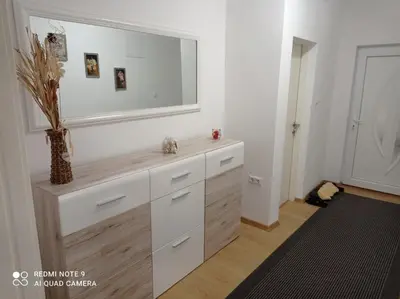 a bathroom with a vanity with a large mirror at DALMAR Apartman in Bihać