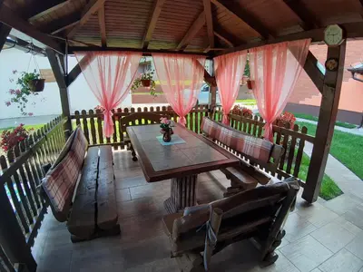 a wooden table and benches on a patio at DALMAR Apartman in Bihać