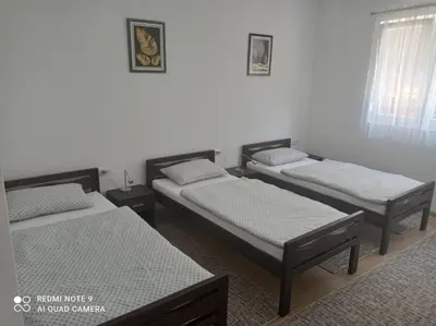 a room with three beds and a window at DALMAR Apartman in Bihać