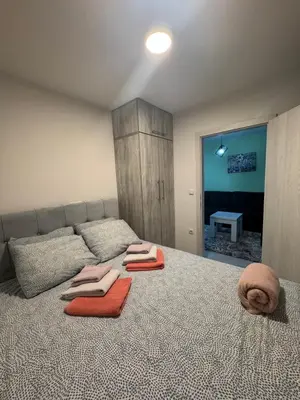 a bedroom with a bed with orange towels on it at Mini apartman Smile Travnik in Travnik
