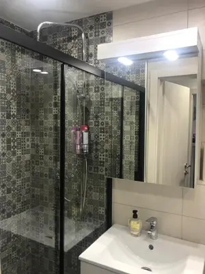 a bathroom with a shower and a sink and a mirror at Mini apartman Smile Travnik in Travnik
