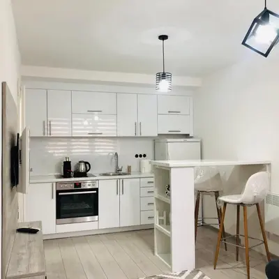 a white kitchen with white cabinets and a counter at Mini apartman Smile Travnik in Travnik