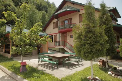 a picnic table and benches in front of a building at Malak Farma in Kakanj