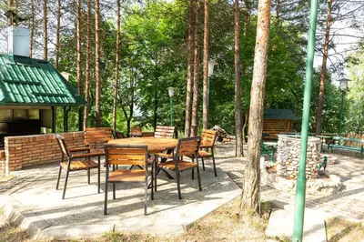 a wooden table and chairs on a patio at Malak Farma in Kakanj