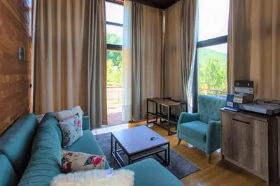 a living room with a blue couch and two chairs at Malak Farma in Kakanj