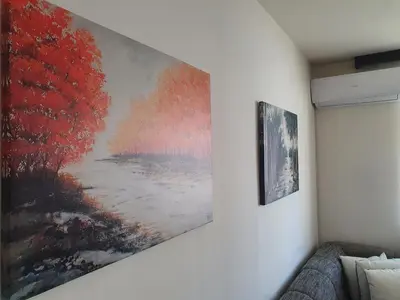 a painting hanging on a wall next to a couch at Diamond M Apartment in Bihać