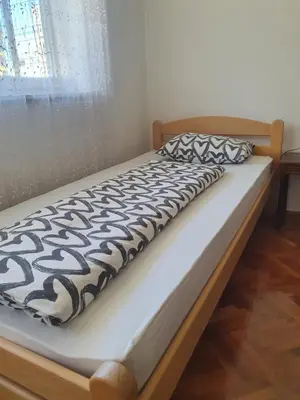 a bed with a black and white comforter and a window at Diamond M Apartment in Bihać