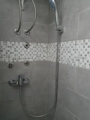 a shower in a bathroom with a glass shower at Diamond M Apartment in Bihać