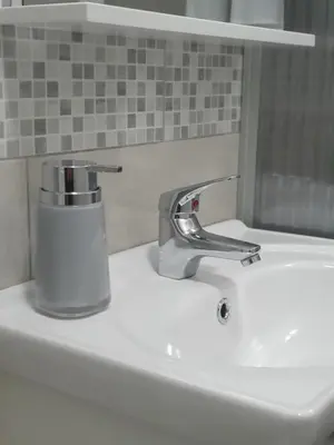 a bathroom sink with a chrome faucet on it at Diamond M Apartment in Bihać