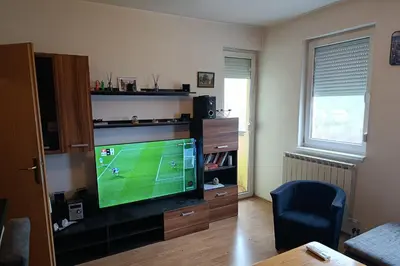 a living room with a television with a soccer game on it at Apartman MM , Banja Luka, Wi-Fi free,parking free in Banja Luka