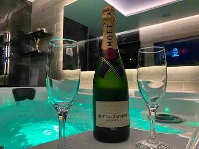 a bottle of wine and two glasses on a table at Spa Intimo Doboj in Doboj