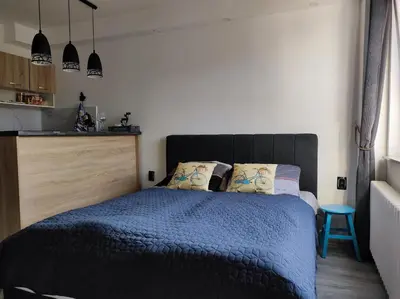 a bedroom with a bed with a blue comforter at Cozy studio Cik-Cak in Doboj