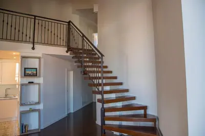 a wooden staircase in a house with a kitchen at Penthouse Linnet Bihać in Bihać