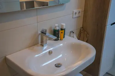 a white sink in a bathroom with a mirror at Penthouse Linnet Bihać in Bihać