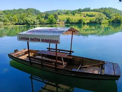 a boat with a sign on it on the water at Apartments Marshal in Bosanska Krupa
