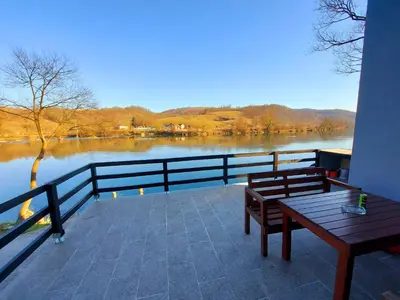a balcony with two benches and a view of a lake at Apartments Marshal in Bosanska Krupa