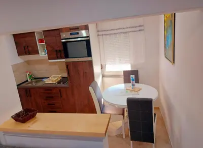 a small kitchen with a table and a small table and chairs at Apartments Marshal in Bosanska Krupa