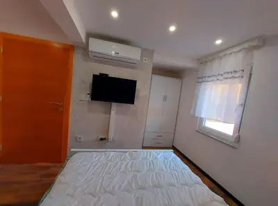a bedroom with a bed and a tv on the wall at Apartments Marshal in Bosanska Krupa