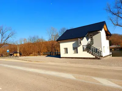 a small white house on the side of a road at Apartments Marshal in Bosanska Krupa