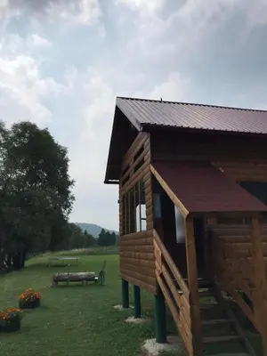 a small wooden cabin with a bench in a field at Vikendica Na Plivi in Šipovo