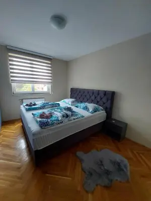 a bedroom with a bed and a window and a rug at LNB Lux in Doboj