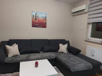a living room with a black couch and a table at LNB Lux in Doboj