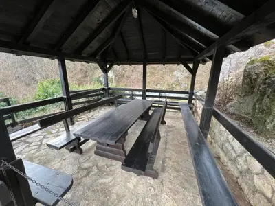a wooden picnic table in a pavilion with a view at Vikendica Mlinovi in Krupa na Vrbasu
