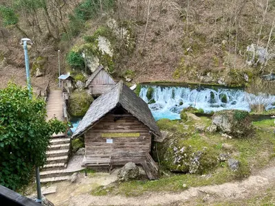 a small wooden cabin next to a waterfall at Vikendica Mlinovi in Krupa na Vrbasu