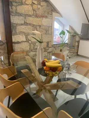 a glass table with a vase on top of it at KARTAL centar apartment in Bihać