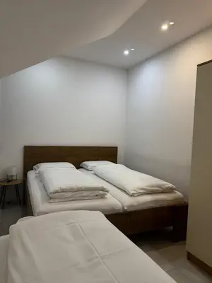 two beds in a room with white walls at KARTAL centar apartment in Bihać
