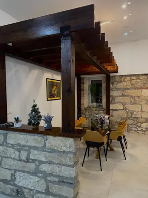 a dining room with a table and a stone wall at KARTAL centar apartment in Bihać