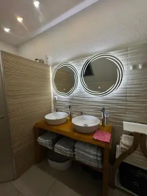a bathroom with two sinks and two mirrors on the wall at KARTAL centar apartment in Bihać