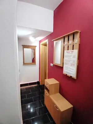 a bathroom with a red wall and a box on the wall at Pansion San in Bihać