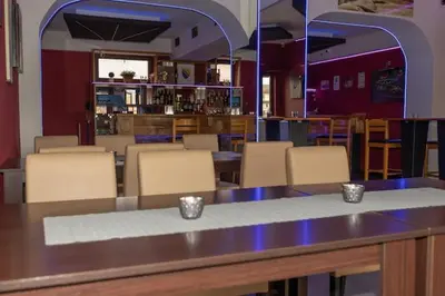 a restaurant with a table and chairs and a bar at Pansion San in Bihać