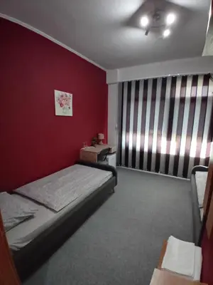 a bedroom with a bed and a red wall at Pansion San in Bihać