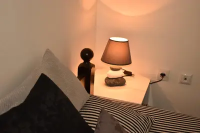 a bedroom with a bed with a lamp on a night stand at Apartman Archive Jevrejska in Banja Luka