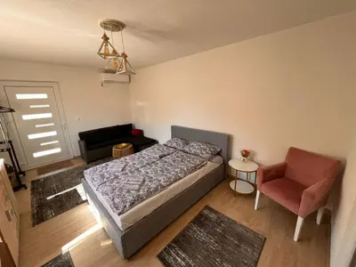 a small bedroom with a bed and a chair at City apartment 2 in Visoko