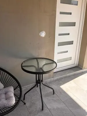 a glass table and a chair next to a door at City apartment 2 in Visoko