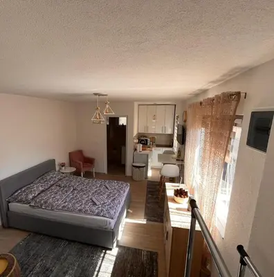 a bedroom with a bed and a living room at City apartment 2 in Visoko