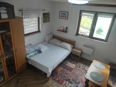 a small bedroom with a bed and a window at Dreamhouse Bosnia in Visoko