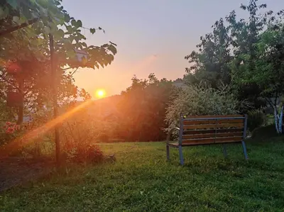 a bench in a field with the sunset in the background at Dreamhouse Bosnia in Visoko