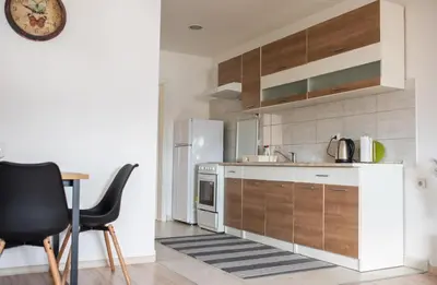 a kitchen with a refrigerator and a table and chairs at Apartman Luca in Livno