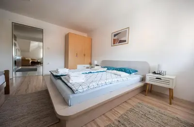a bedroom with a large bed and a night stand at Apartman Luca in Livno