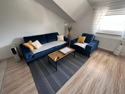 a living room with a blue couch and a table at Apartman Luca in Livno