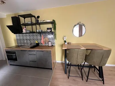 a kitchen with a counter and a table and a table and chairs at Apartman Anđela in Livno