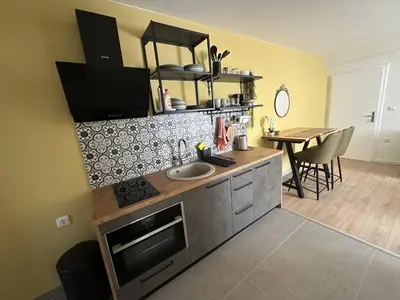 a kitchen with a sink and a counter with a table at Apartman Anđela in Livno