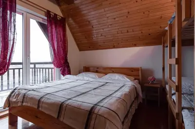 a bedroom with a bed and a large window at Villa Ela in Kupres