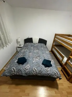 a bedroom with a bed with blue pillows on it at Apartman Bošnjak Ramsko jezero in Podbor